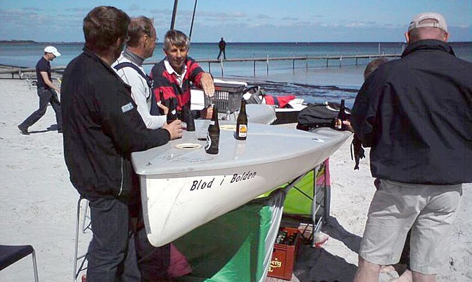 OK-jolle sejlerne er kendt for aldrig at kede sig. Her ses de i en ølpause ved en improviseret Europajolle strandbar.