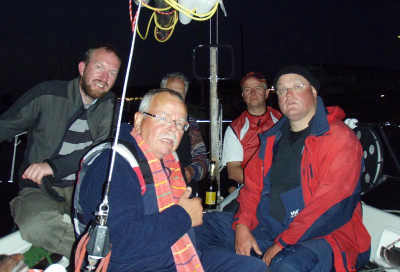 En glad og træt besætning i mål Helsingør havn, efter halvandet døgn i regn og rusk. Skipper Niels Kjøng i forgrunden, Finn Nielsen (tv), lidt gemt bag skipper, Anders Jacobsen, Anders Høck Hansen og Ravn Larsen. Foto: heureka