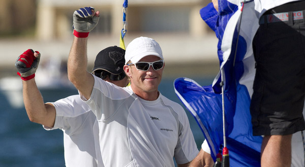 Jesper Radich i front vinker til publilum efter han nu er i finalen på Bermuda med Rasmus Køstner. Begge har deltaget i America's Cup på hhv. Desafio Espaniol og Mascalzone Latino.