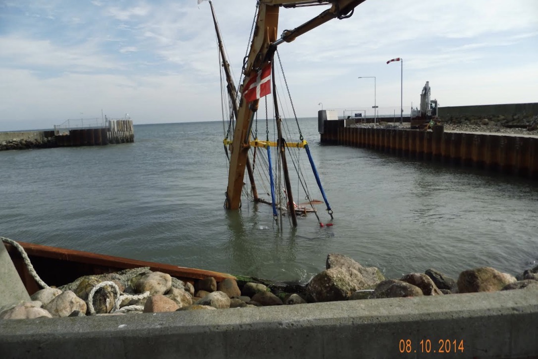 Efter en mislykket bugsering endte ”Skibet” på bunden af Spodsbjerg Havn i 2014. Der gik hul på skroget, da ”Skibet” blev slynget af bølgerne mod kajkanten. Foto: Lise Seidelin