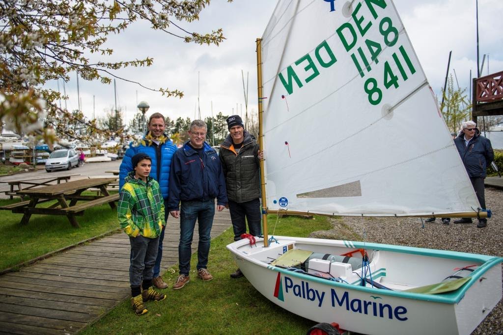 Lokal juniorsejler samt Henrik Jørgensen, Tempo Bådsalg A/S, formand for Vallensbæk Sejlklub Kenneth Bøggild og topsejler Michael Hestbæk ses her ved den nyindkøbte Opti. Foto: Tempo Bådsalg